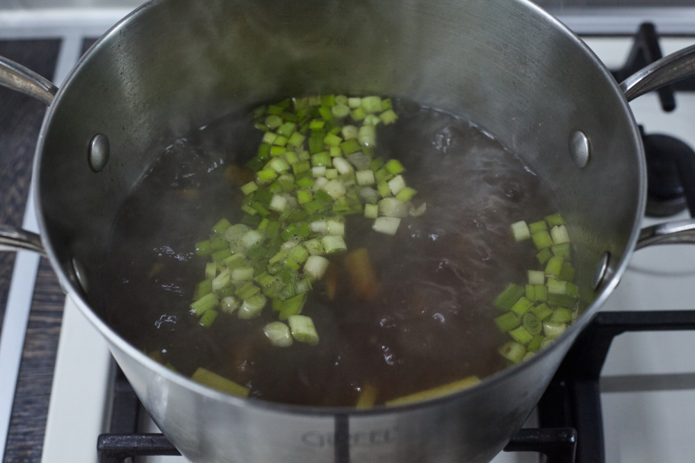 Добавляем в бульон лук, имбирь, соевый соус, уксус, анис для легкого супа в азиатском стиле с гречневой лапшой и лососем