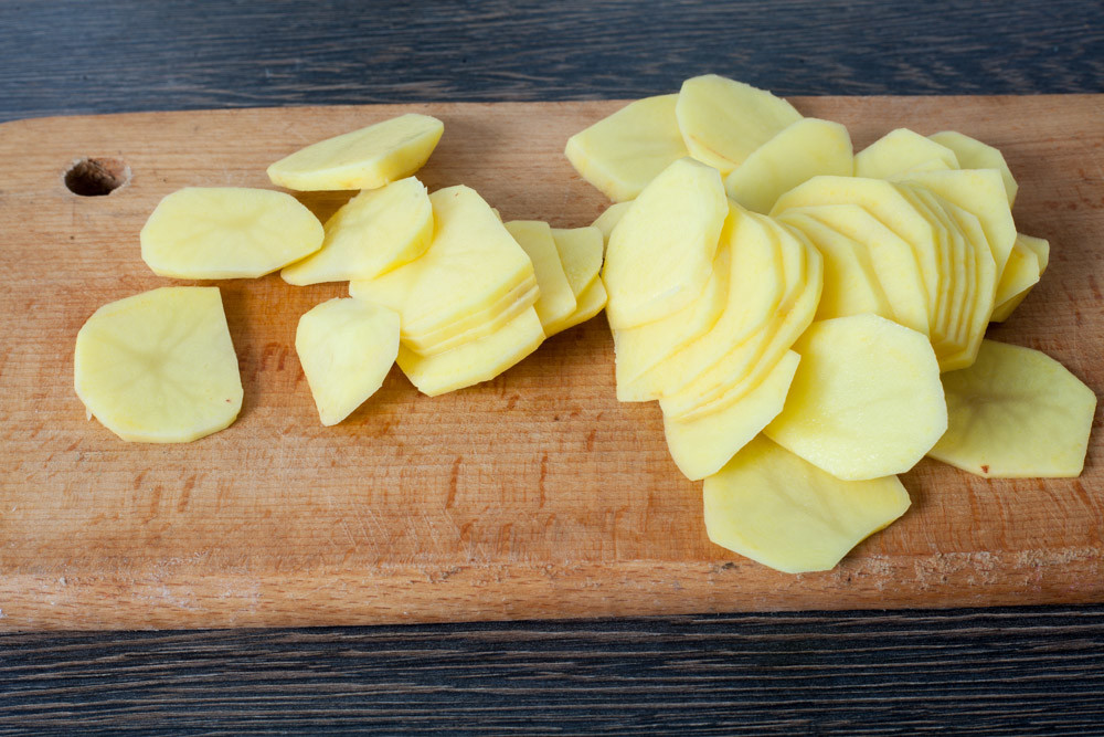 Наріжте картоплю для приготування вегетаріанського супу з картоплі та цибулі порею