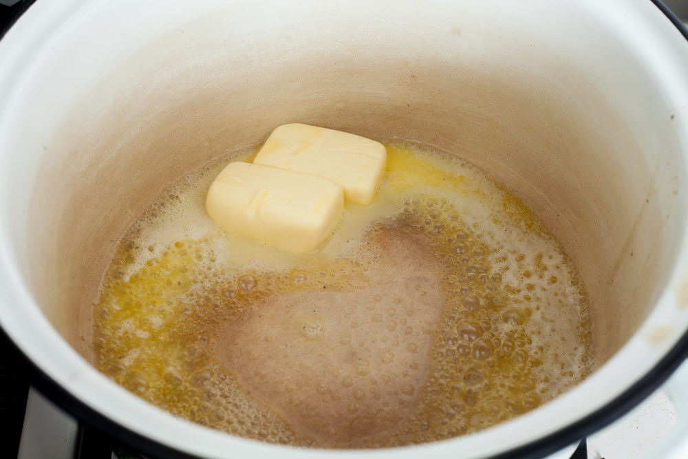 Розтопіть вершкове масло для приготування супу з картоплі та цибулі порею