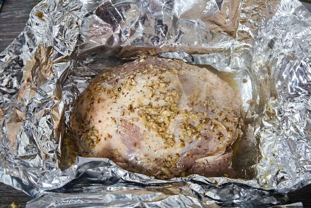 Put the meat on the foil and pour the sauce for cuban roast pork shoulder