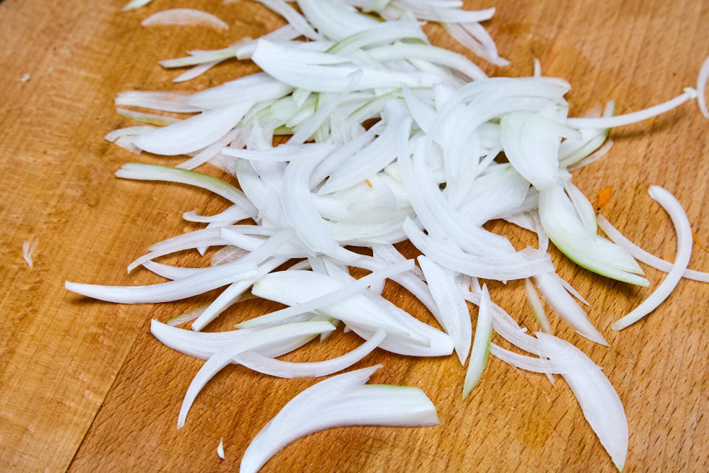 Slice the onion into a thin halflings for cabbage salad coleslaw from jamie oliver