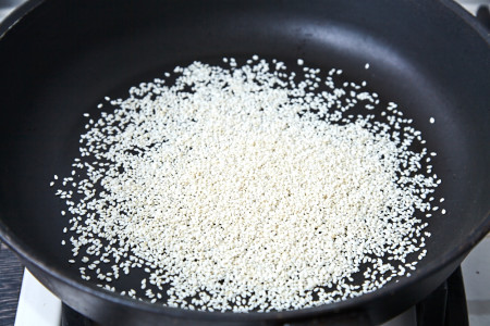 На сухій сковороді підсмажте 2 ст. ложки насіння кунжуту до появи приємного аромату та золотистого кольору. Кунжут перекладіть у суху тарілку і відставте убік.