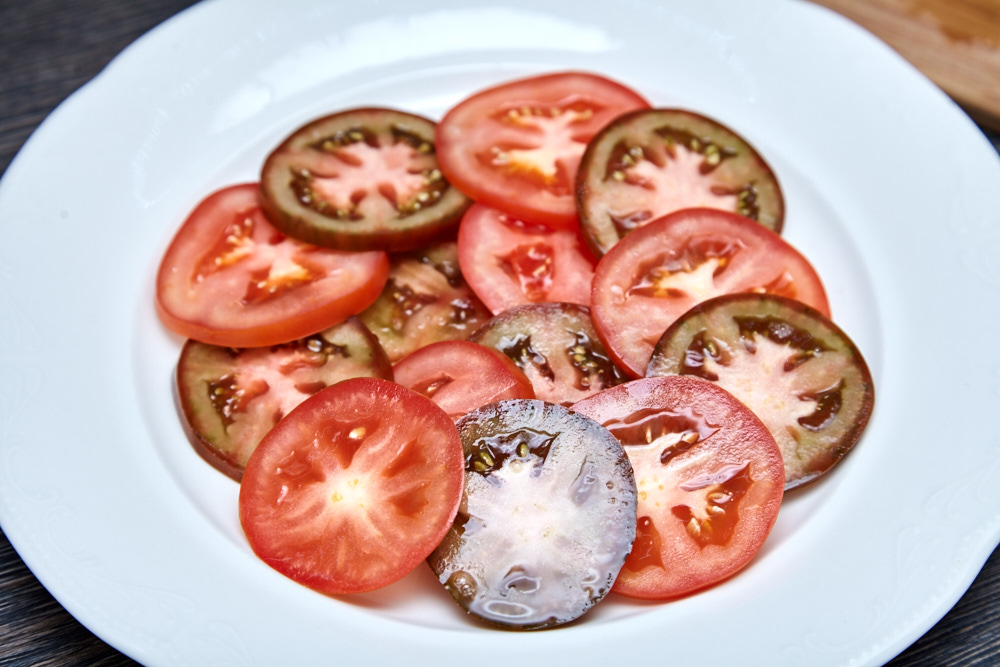 Выкладываем помидоры на тарелку для салата капрезе