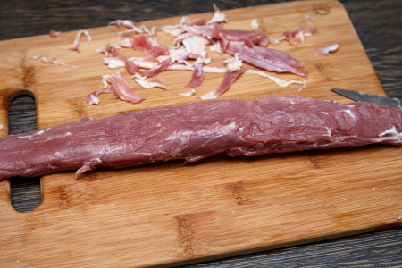 Зріжте з м'яса зайвий жир, видаліть плівки та прожилки для приготування свинячої вирізки в техаському стилі