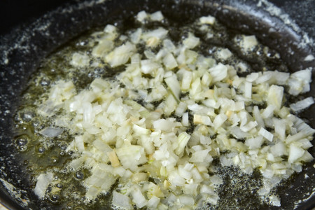 Добавляем лук в сковороду для пасты пенне с соусом из сельдерея