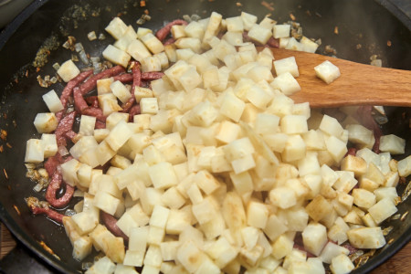 Додайте у каструлю до цибулі та ковбаси відварену селеру. Злегка розімніть товкачем або вилкою. Додайте до соусу, що вийшов, 50-150 мл молока та перемішайте.