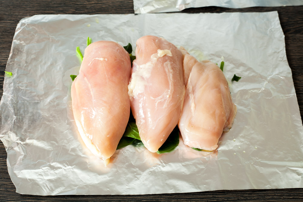 Сверху кладем куриные грудки для куриных грудок с розмарином и шпинатом в конверте из фольги за 15 минут