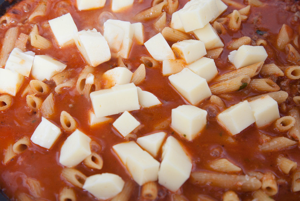 Знімаємо кришку, добре перемішуємо і додаємо половину нарізаної моцарели для американського чоп-суей: макарони в томатному соусі з фаршем і сиром.