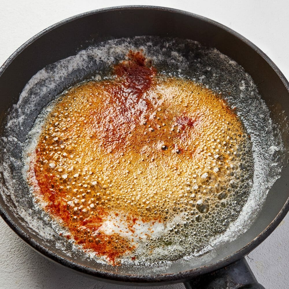 Шаг 5. Для подачи растопите сливочное масло в небольшой сковороде, добавьте паприку и перемешайте. Разлейте суп по тарелкам и полейте растопленным маслом.