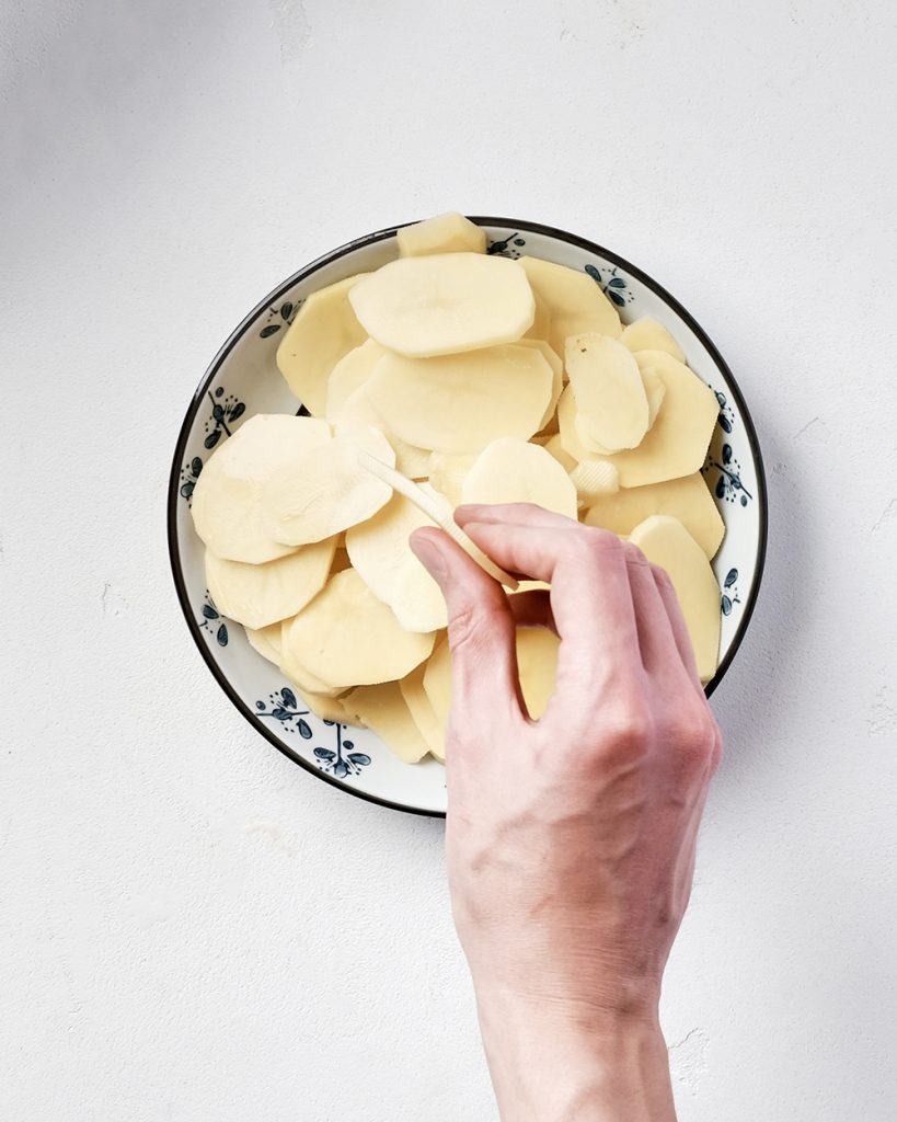 У цей час помийте, очистіть і наріжте картоплю тонкими скибочками, завтовшки близько 5-6 мм. Натріть 75 гр пармезану на дрібній тертці.