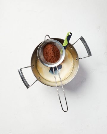 Brigadeiro cooking process: mixing cocoa powder and sweetened milk 