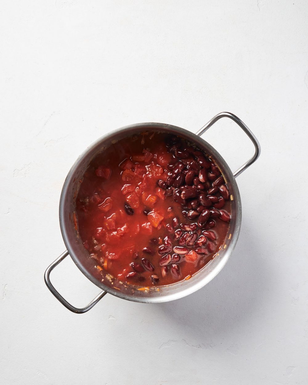 Добавьте к чили томаты и красную фасоль