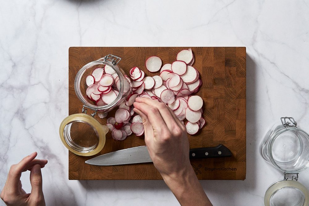 Transfer sliced radishes into jars