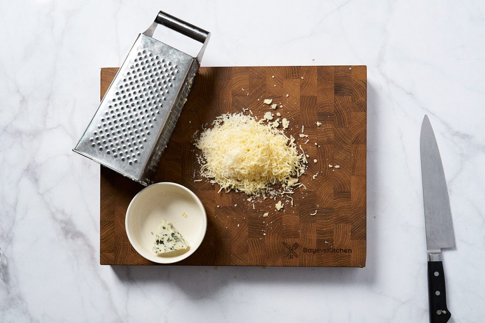 Grate the parmesan and cheddar on a fine grater. Grate the blue cheese with your hands. Set aside