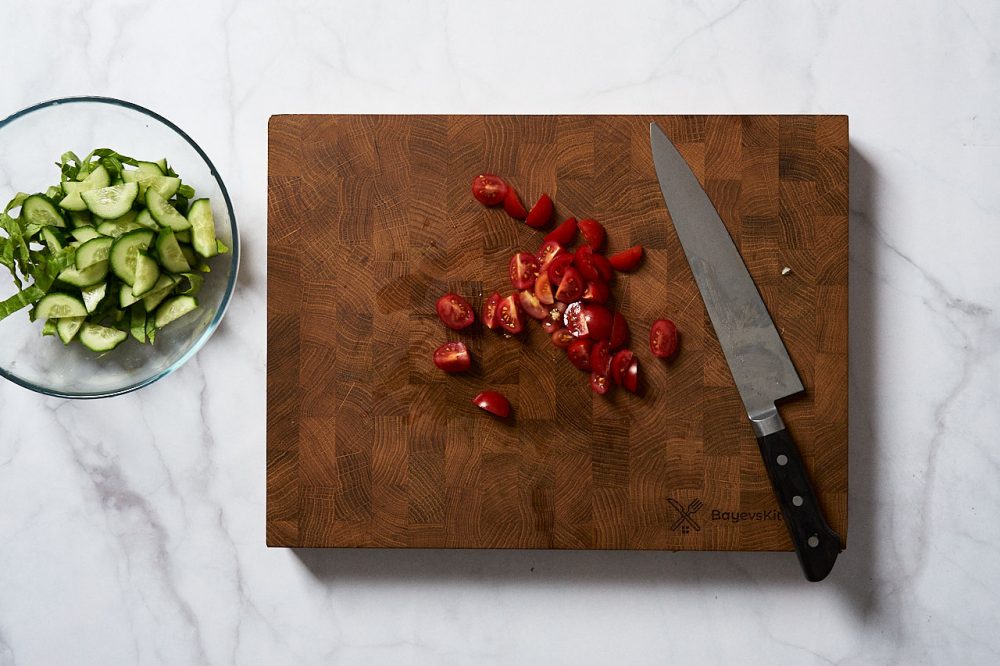 Наріжте помідори черрі на чверті або половинки.