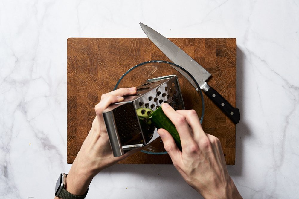  Grate 150 grams of cucumber on a coarse grater.