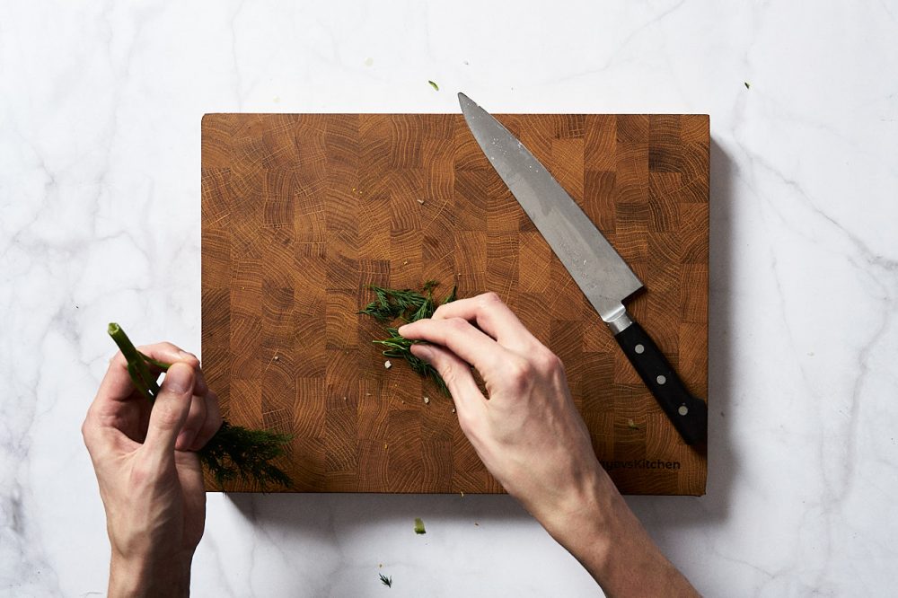 Відірвіть зелень кропу від стебел і дрібно порубайте ножем.