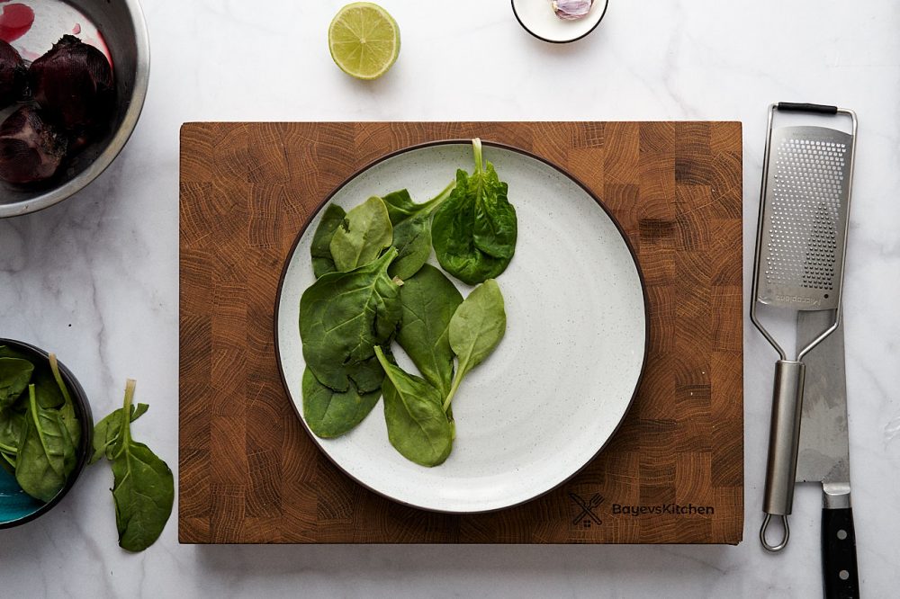 Розкладіть шпинатне листя на тарілці.
