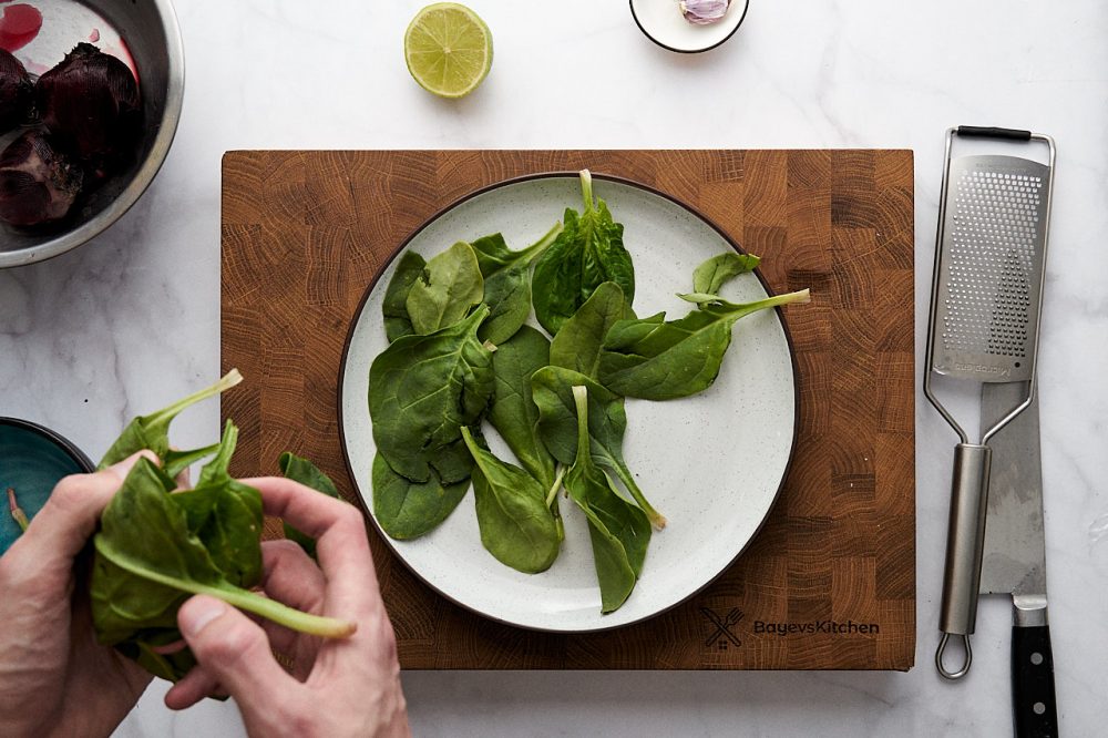Розкладіть шпинатне листя на тарілці.