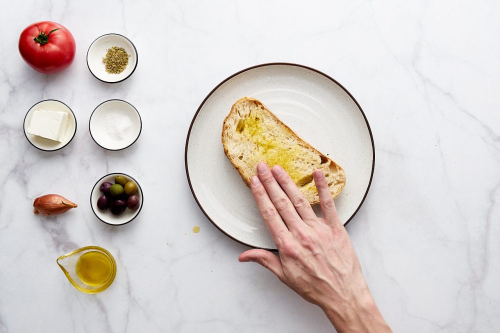 Смажьте кусок хлеба оливковым маслом