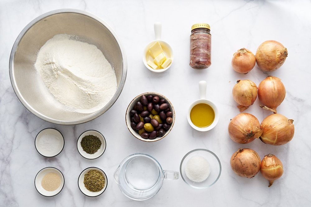 Ingredients for making pissaladier pie: flour, salt, yeast, water, oregano, thyme, onion, butter, olive oil, sugar, 