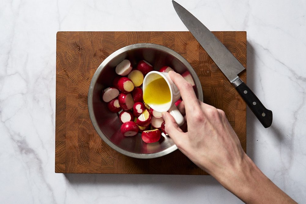 Add olive oil to the bowl with the radishes