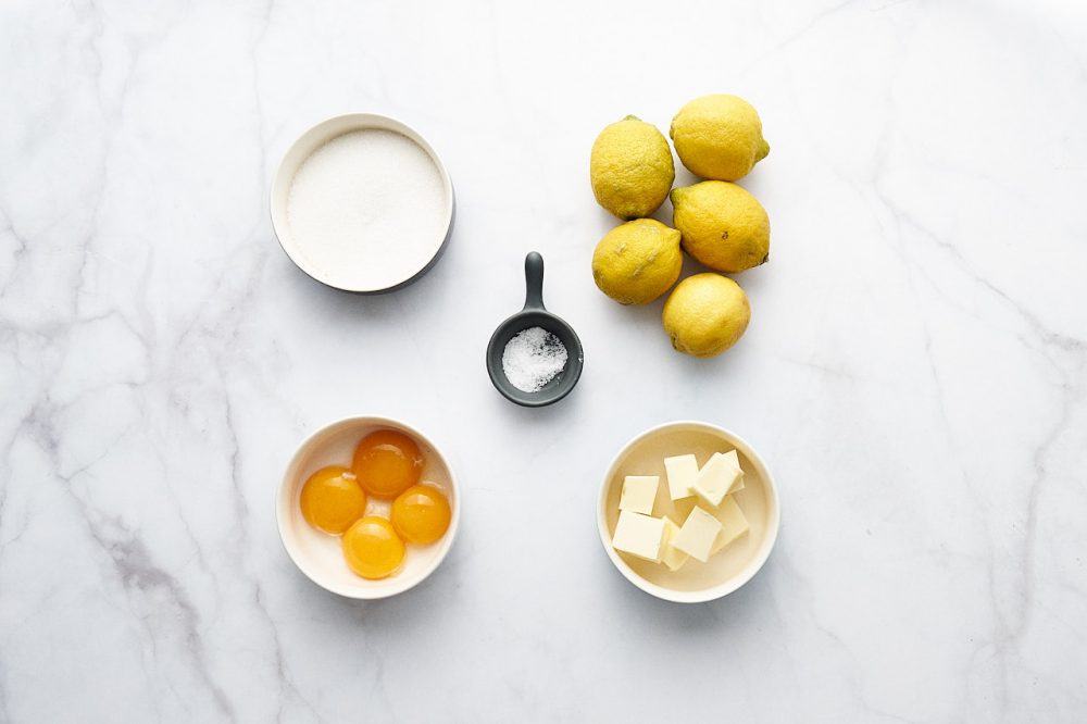 Ingredients for making lemon curd: lemons, egg yolks, sugar, salt, butter
