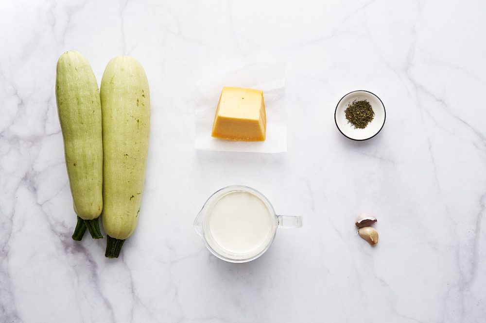 Ingredients for cooking zucchini in cream-garlic sauce with cheese: zucchini, cheese, cream, garlic, thyme, salt.