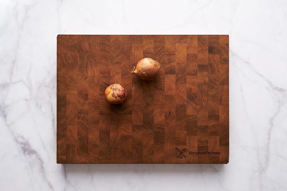 Unpeeled onions on a cutting board