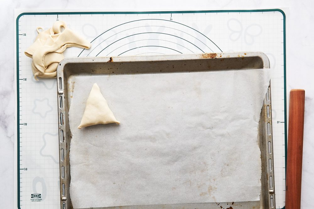 Place a triangle of dough on the baking tray with the filling