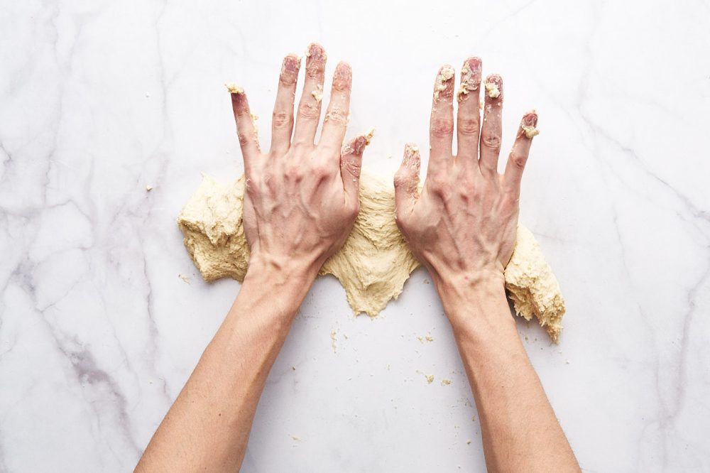 Викладіть тісто на робочу поверхню та замішуйте тісто 10-15 хвилин