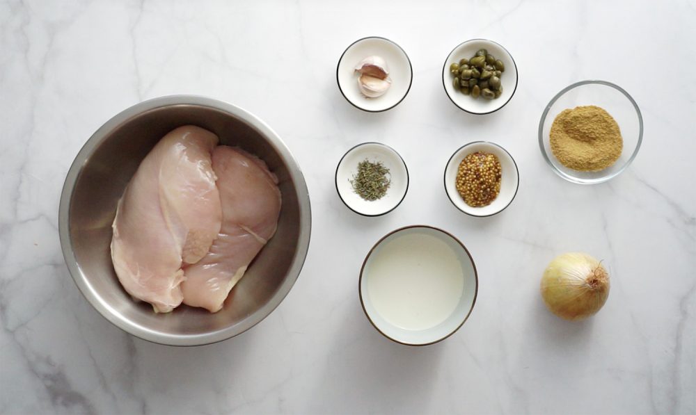 Ingredients for cooking chicken breasts in mustard cream sauce: chicken filet, onions, garlic, cream, thyme, mustard powder, mustard grainy, chives.
