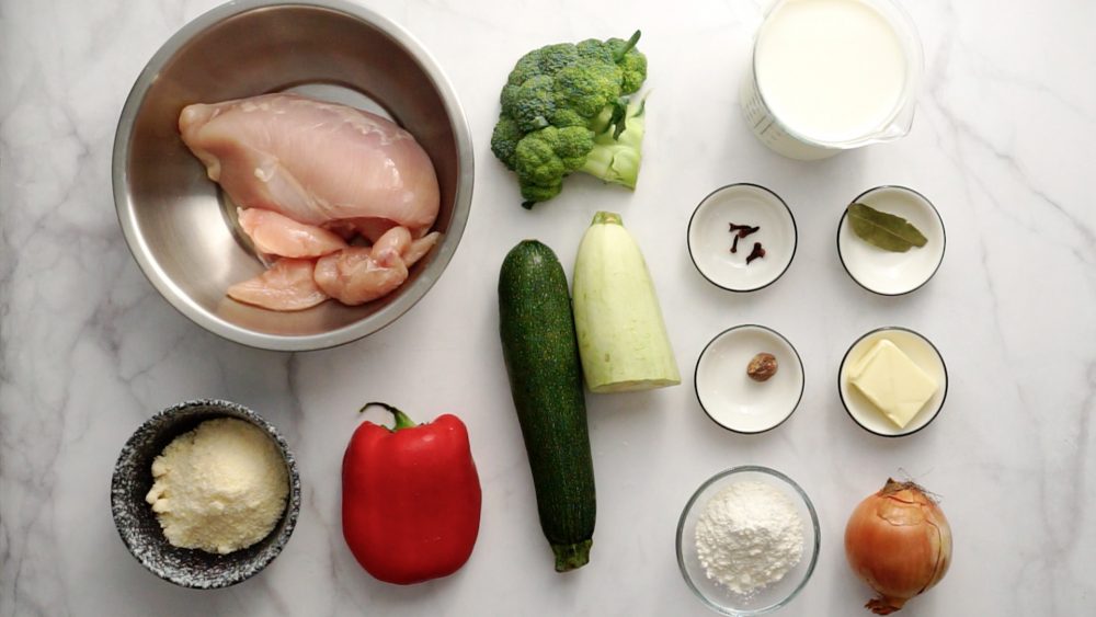 Інгредієнти для приготування курки з овочами, запеченої під соусом Бешамель: курячі грудки, цукіні, солодкий перець, брокколі, соус Бешамель.