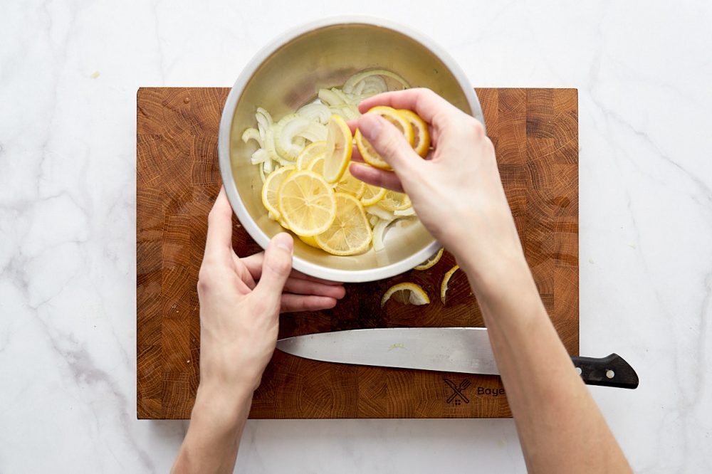Нарізані лимон та цибулю перекладіть у миску.