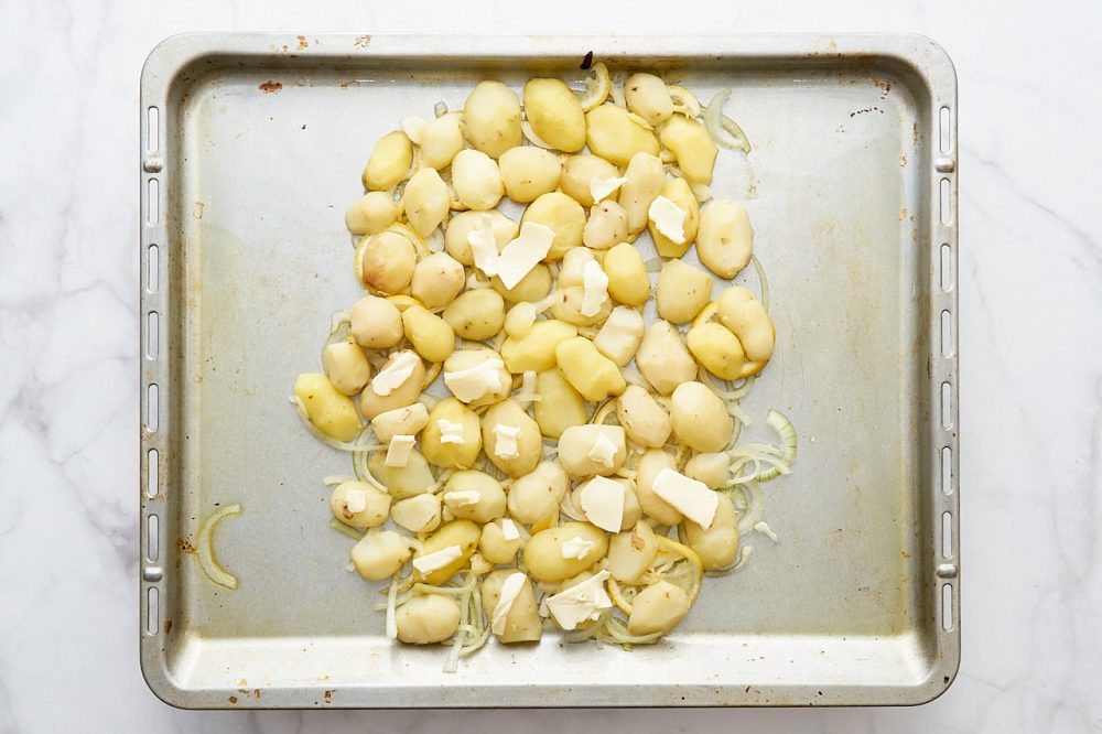 Выложите кусочки сливочного масла на картофель