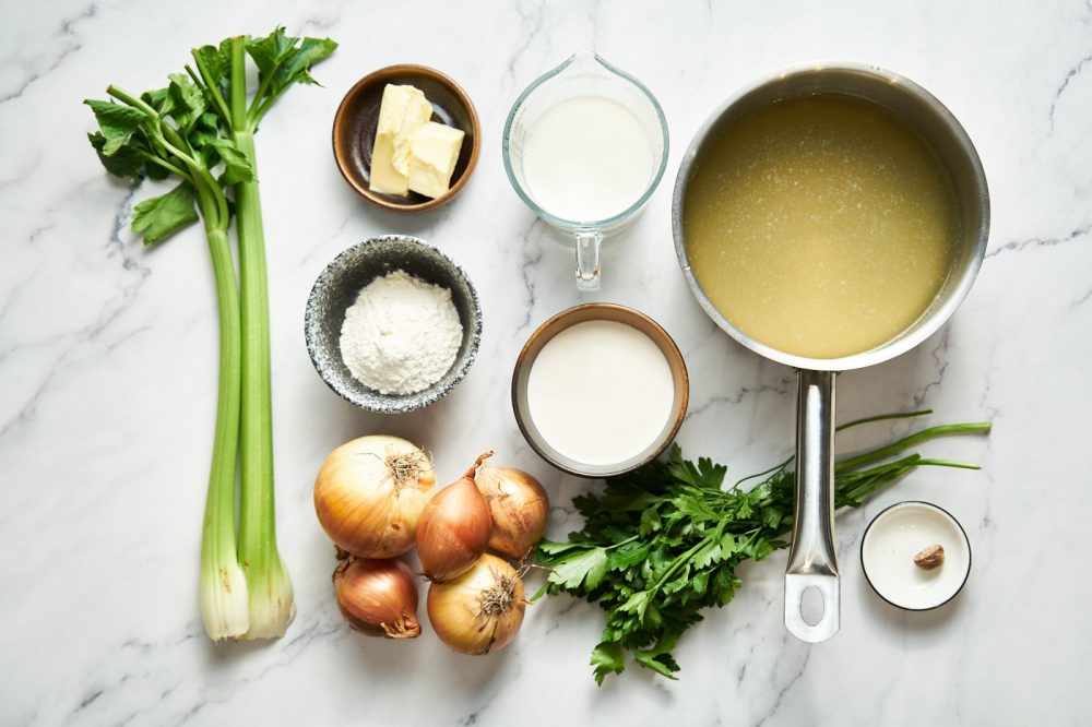 Ingredients for white onion soup: butter, large onions, celery stalks, first class wheat flour, milk, water, chicken stock, nutmeg, salt, black pepper, cream, greens