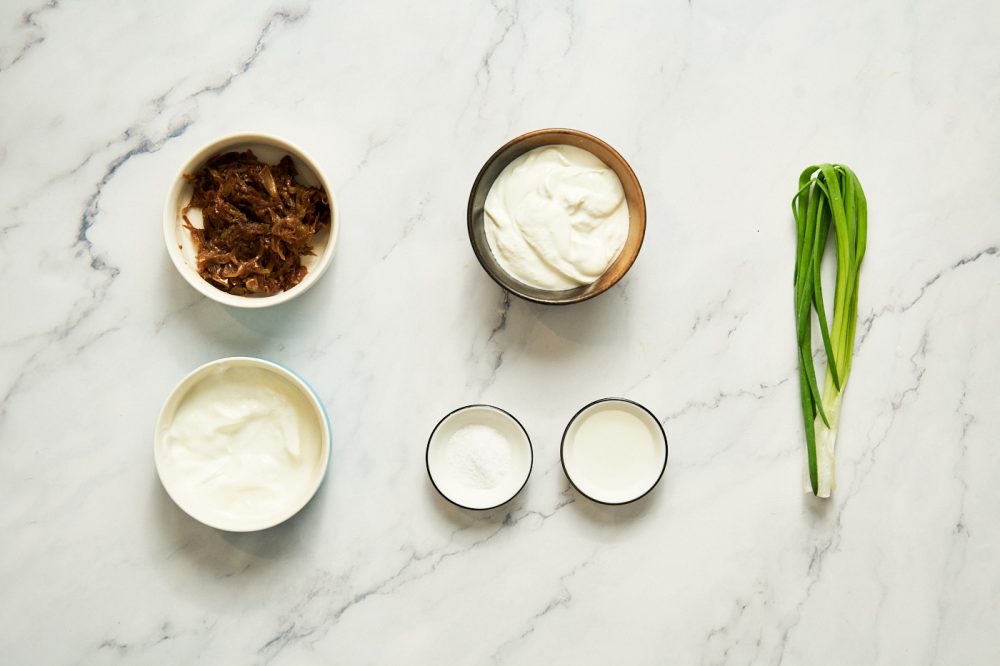 Ingredients needed to make sour cream sauce-dip with caramelized onions: sour cream, caramelized onions, yogurt, green onions, white vinegar, salt, black pepper