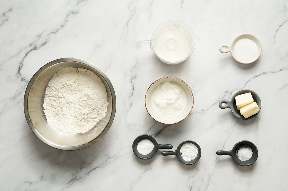 Ingredients for making eggless pancakes: milk, yogurt, butter, sugar, flour, baking soda, baking powder, salt