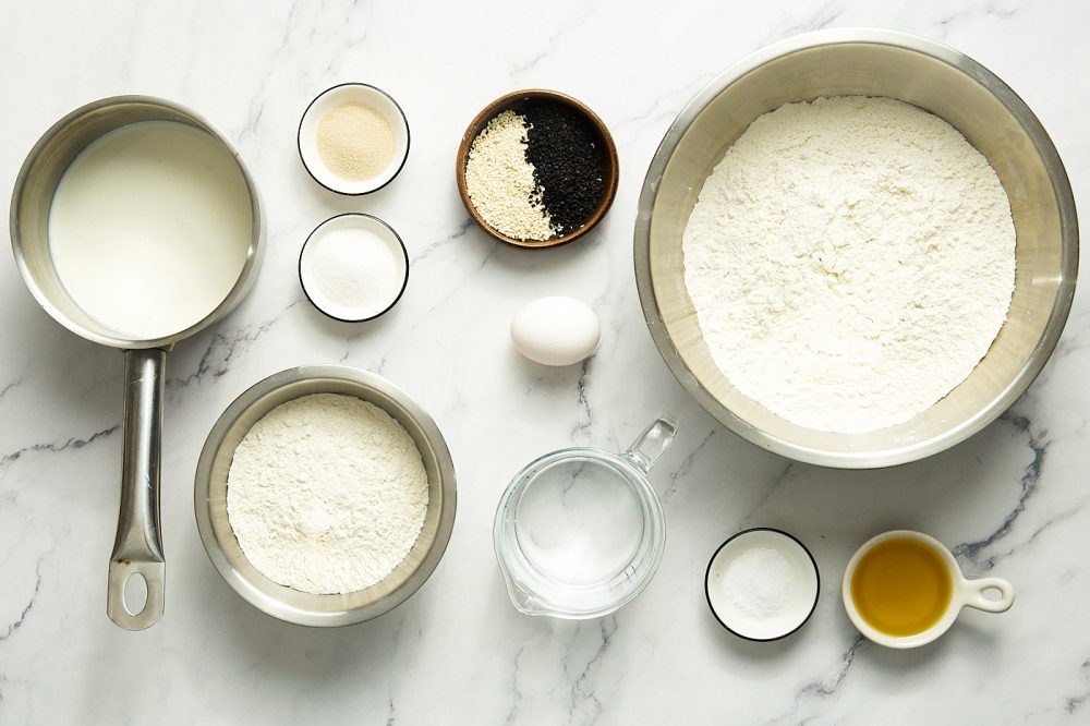 Ingredients needed to make Ramadan pita: milk, flour, yeast, sugar, water, olive oil, salt, egg powder, sesame seeds, nigella.