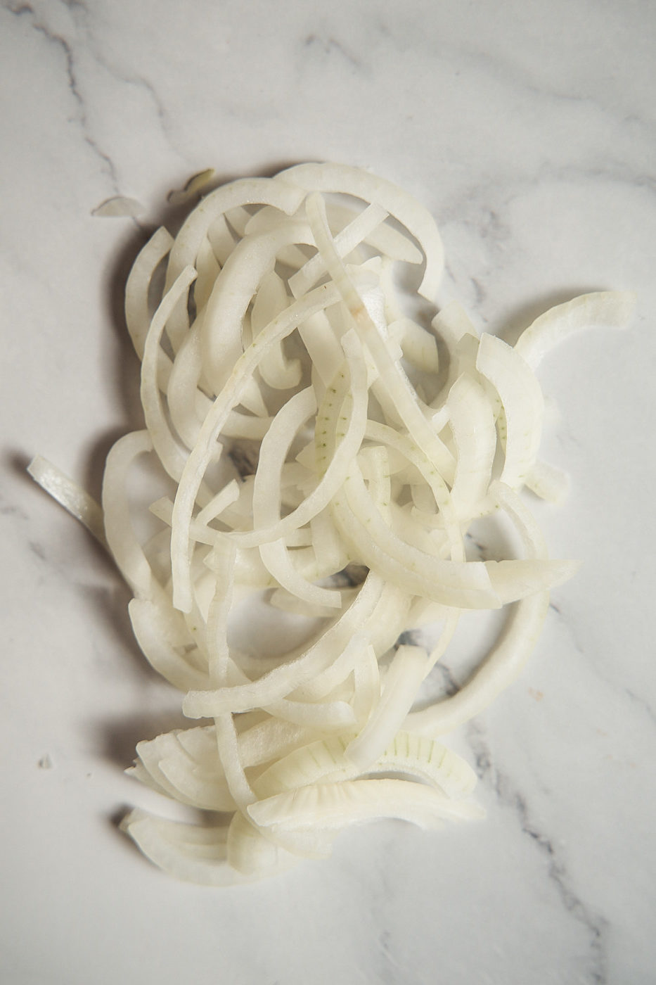 Half-rings or moon-sliced onions on the countertop