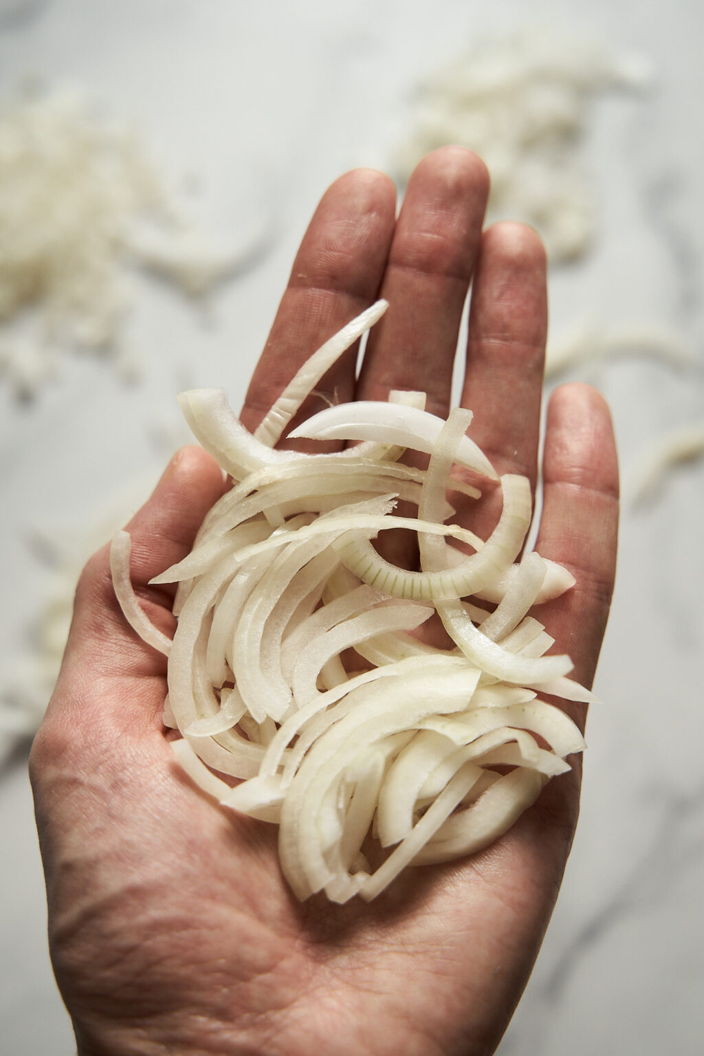 Half-rings or moon-sliced onions in the hand