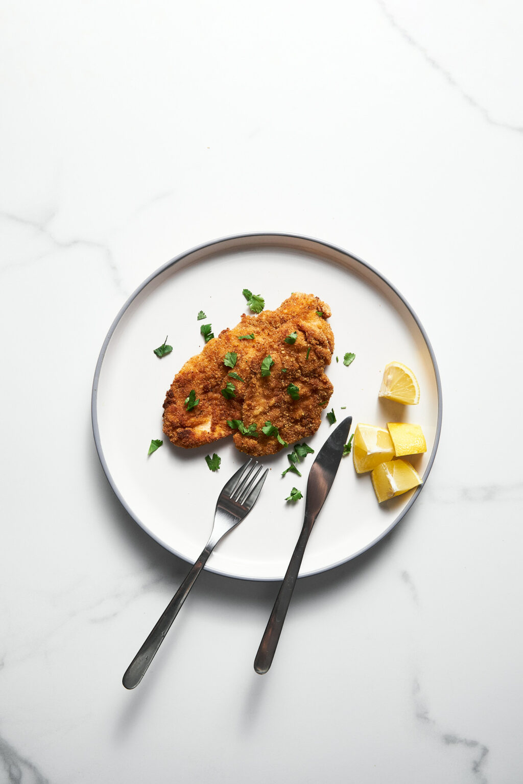 Baked chicken schnitzel with lemon on a plate