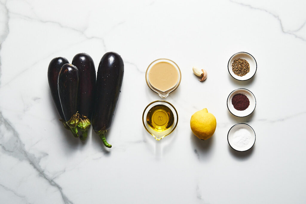 Ingredients needed for making mutabal: eggplant, garlic, tahini, lemon, salt, olive oil, zira, sumac