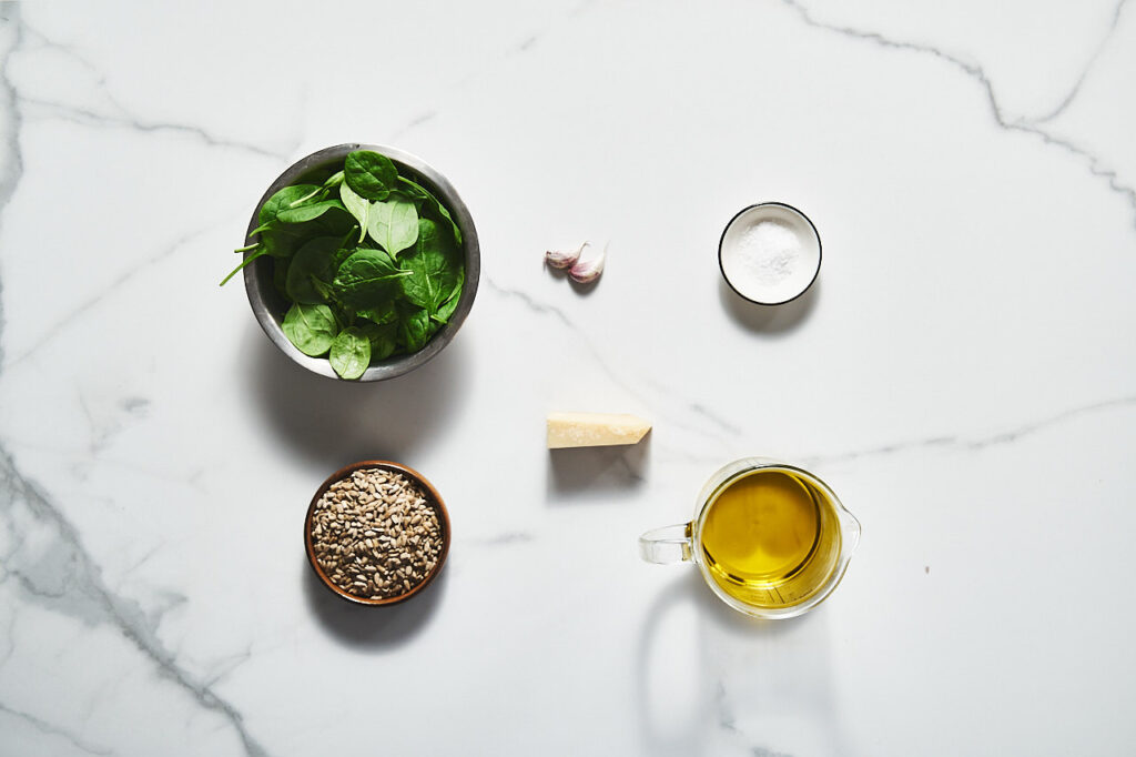 Ingredients needed to prepare Pesto with sunflower seeds and spinach: fresh spinach leaves, sunflower seeds, garlic, parmesan cheese, olive oil, salt and pepper