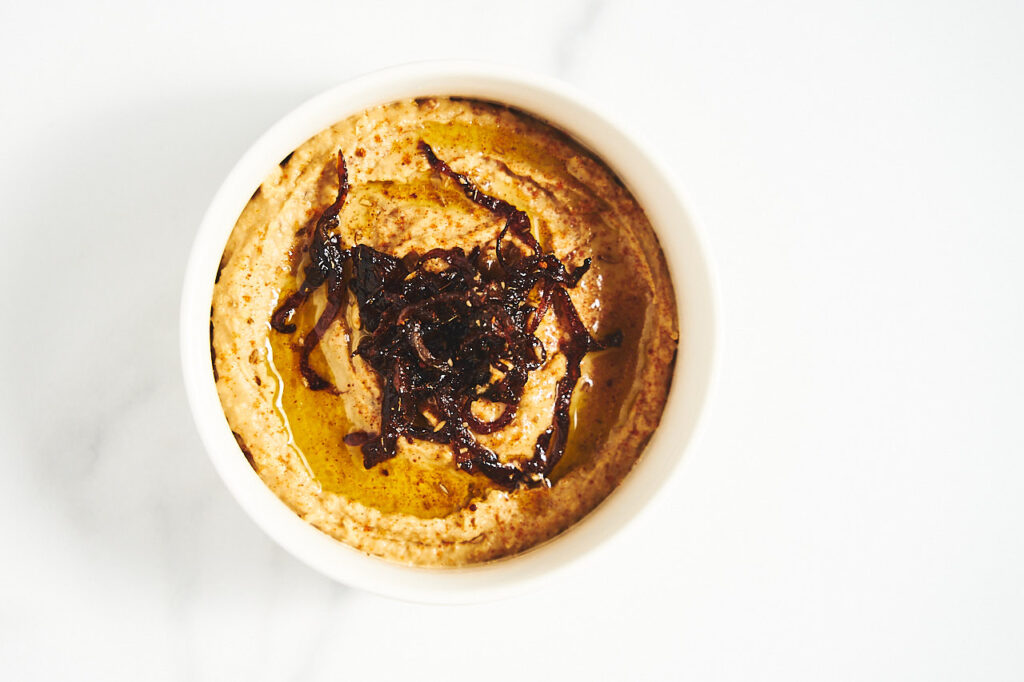 Hummus with caramelized onions and balsamic vinegar in a bowl