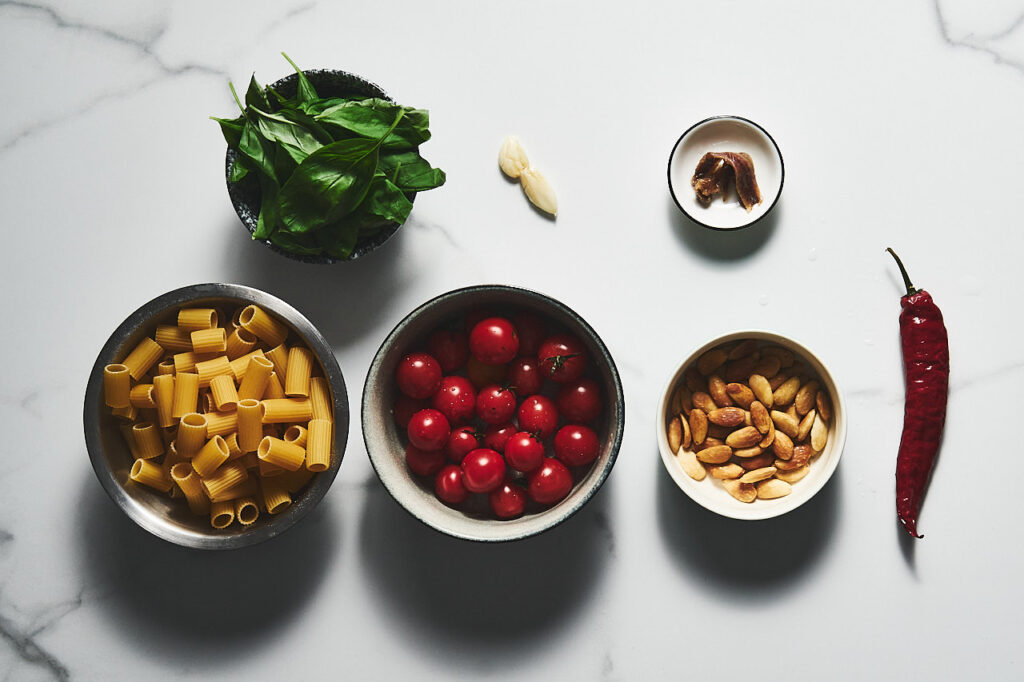 Ингредиенты необходимые для приготовления Пасты Ригатони от Джейми Оливерас сицилийским соусом песто: ригатони, чеснок, чили, сыр пармезан, миндаль, филе анчоусов, базилик, помидоры черри