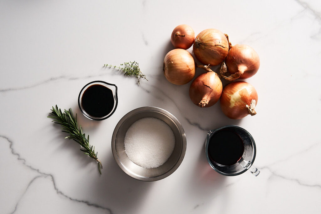 Ingredients needed to prepare Onion Confit with Port Wine and Rosemary: yellow onion, port wine, rosemary sprigs, thyme sprigs, sugar, balsamic vinegar, vegetable oil, salt